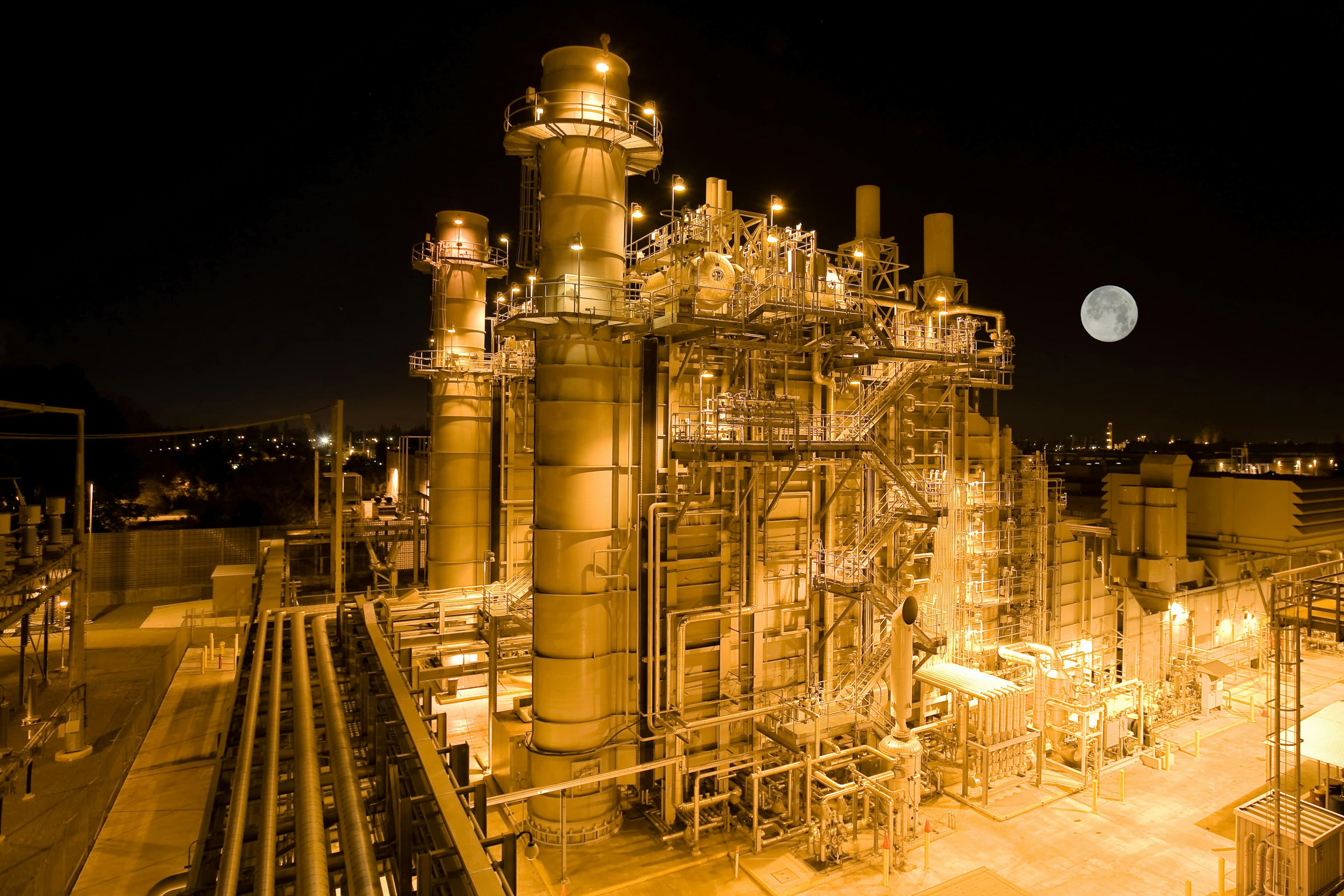 Planta industrial nocturna con instalaciones iluminadas