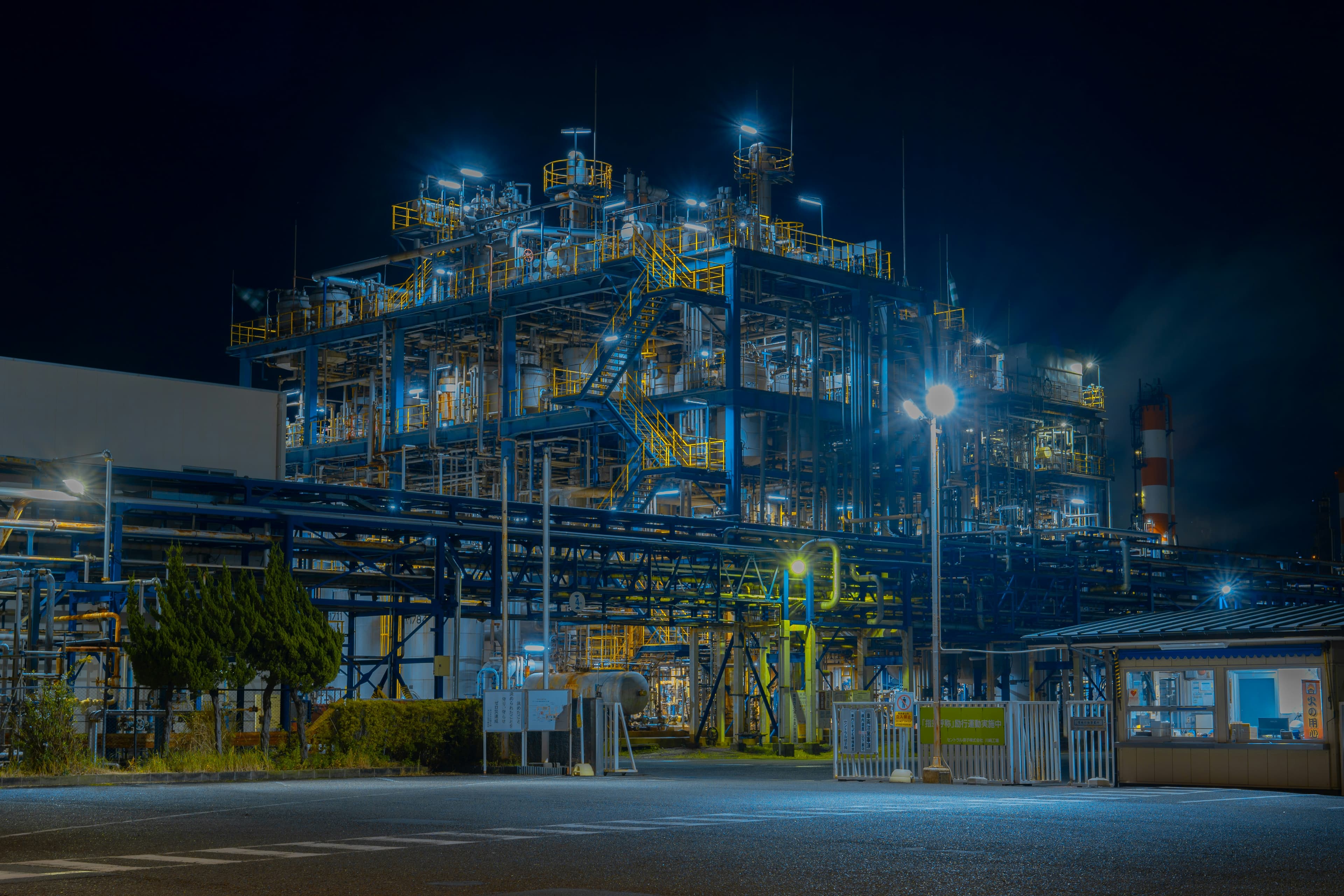 Planta industrial nocturna con instalaciones iluminadas.